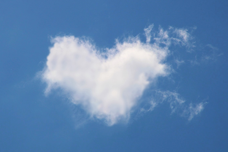 Vitt moln format som ett hjärta på en blå himmel.