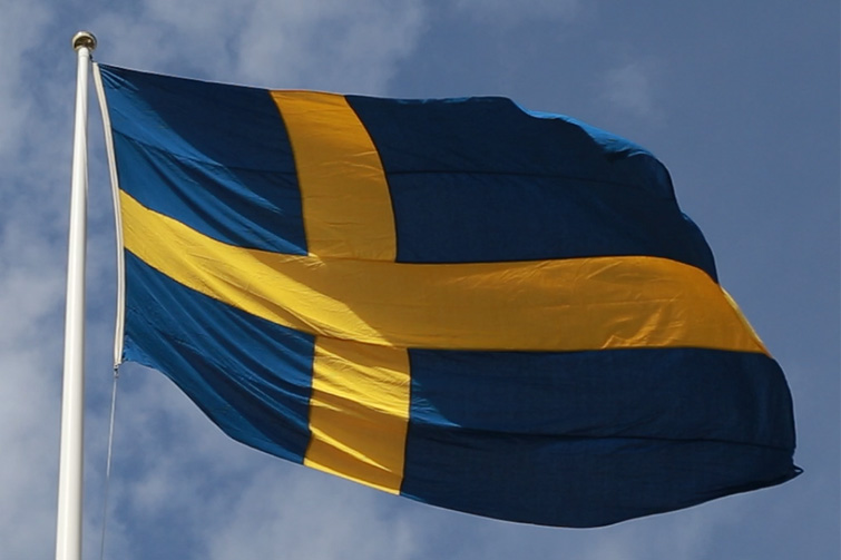 Svenska flaggan som vajar i vinden.