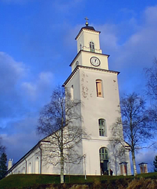 Boda kyrka sträcker sig mot en klarblå himmel. 