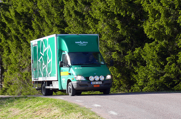 Rullis, en grön mindre lastbil som åker på en landsväg i grönska.