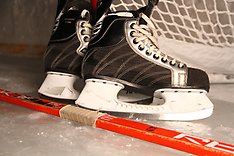 Hockeyskridskor och hockeyklubba som ligger på isen.