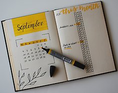 En kalender (bullet journals) som ligger uppslagen på ett bord.