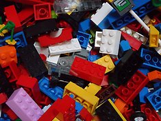 Legobitar i olika färgen i en hög